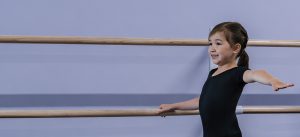 A smiling student at the barre.