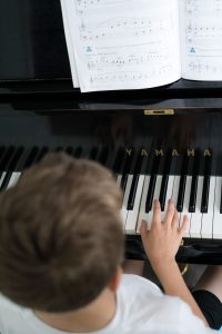 A music student in rehearsal with their fingers on the piano keys.
