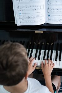 A music student in rehearsal with their fingers on the piano keys.